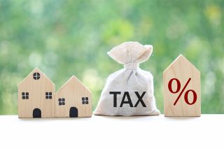 Foto: Häuschen und Beute mit Aufschrift Tax